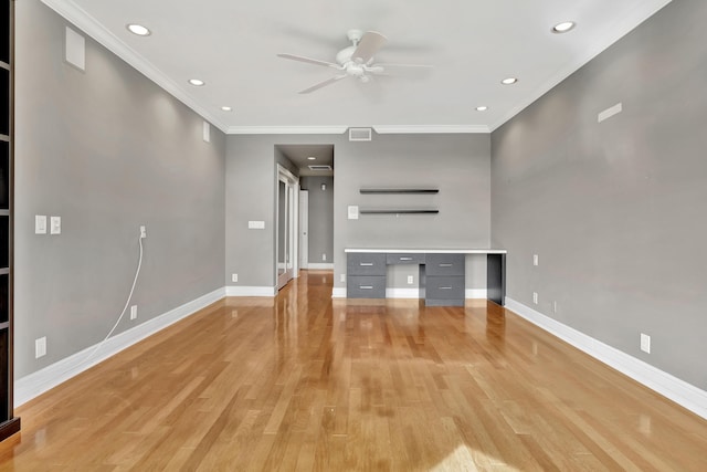 unfurnished living room featuring ornamental molding, built in desk, ceiling fan, and light wood-type flooring