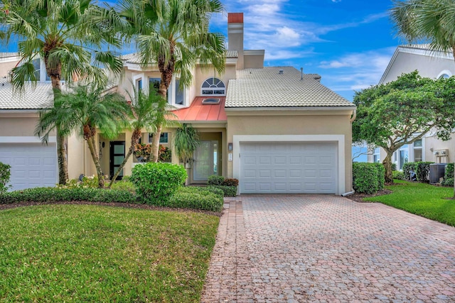 view of front of property featuring a garage, a front yard, and cooling unit