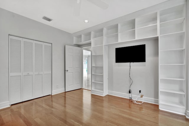 unfurnished bedroom with wood-type flooring, a closet, and ceiling fan