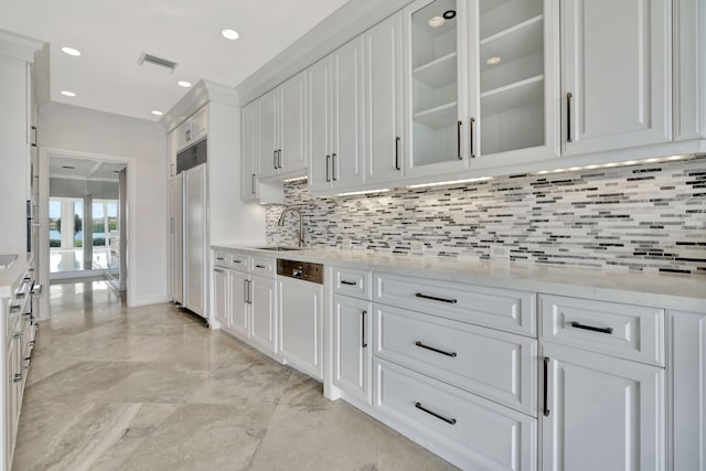 kitchen with white cabinetry, paneled appliances, sink, backsplash, and light stone counters