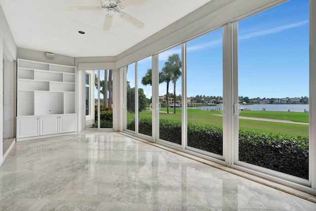 unfurnished sunroom with a water view, ceiling fan, and a wealth of natural light