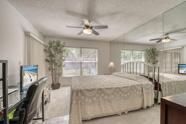 bedroom featuring carpet flooring, a textured ceiling, and ceiling fan