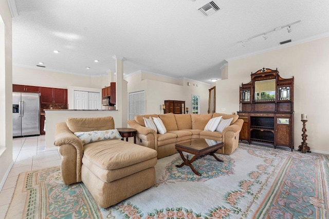 living room with ornamental molding, rail lighting, a textured ceiling, and light tile patterned floors