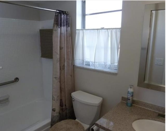 full bathroom featuring vanity, shower / tub combo, and toilet