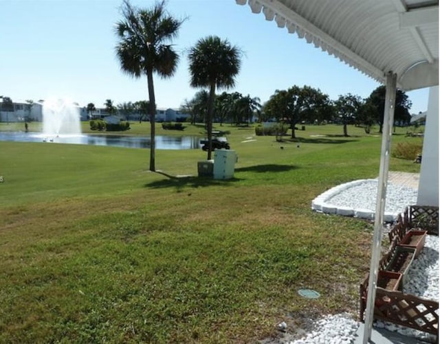 view of community with a yard and a water view