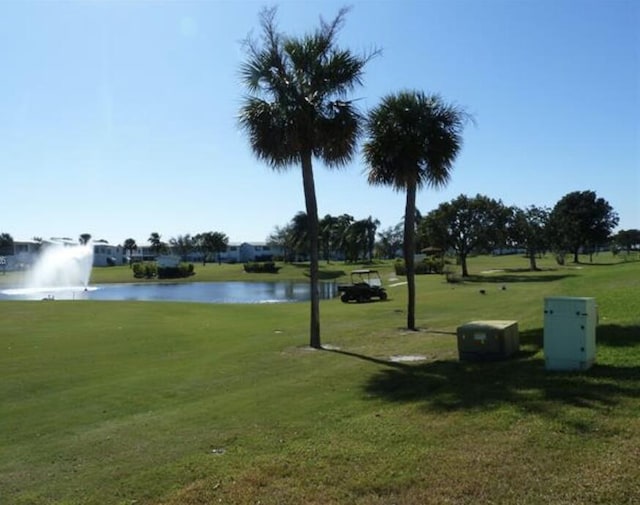 surrounding community featuring a water view and a lawn