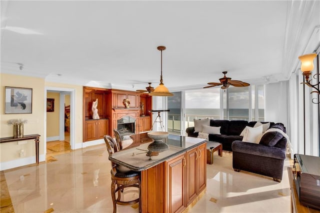 3554 Ocean Dr Unit Ph4S, Vero Beach, FL 32963 - kitchen featuring hanging light fixtures, a center island, baseboards, ceiling fan, and brown cabinets