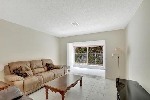 living room featuring a textured ceiling and light tile patterned floors