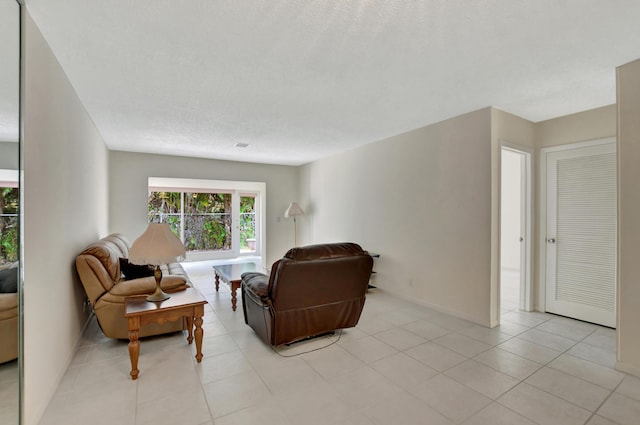 tiled living room featuring a textured ceiling