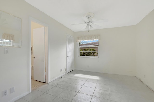 tiled spare room featuring ceiling fan