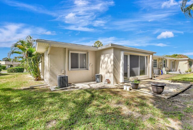 20835 Wendall Ter Unit 68, Boca Raton, FL 33433 - rear view of house with stucco siding, a patio, a yard, and central AC