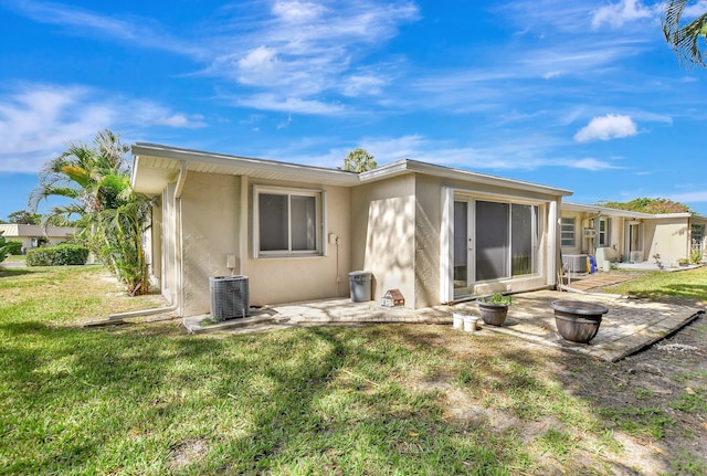 back of house featuring a yard and central AC unit