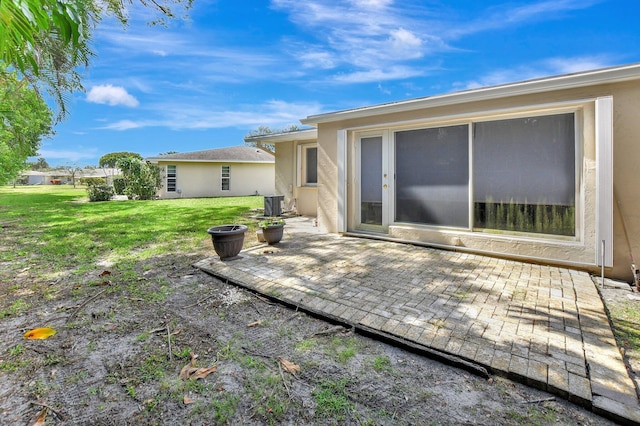 back of property featuring a yard, a patio area, and central AC