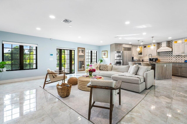 living area with marble finish floor, recessed lighting, visible vents, and baseboards