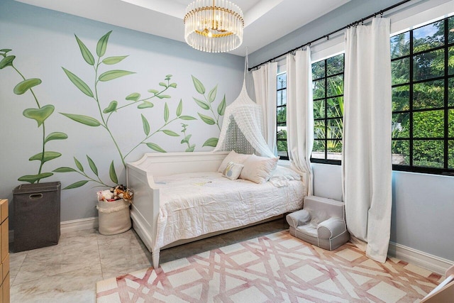 bedroom featuring a chandelier, multiple windows, and baseboards