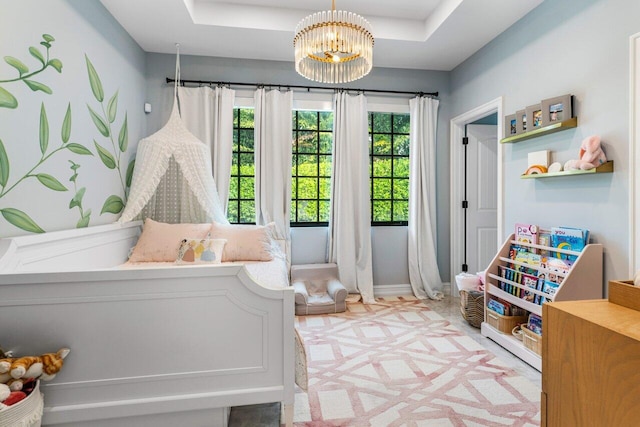 bedroom featuring an inviting chandelier, baseboards, and a raised ceiling