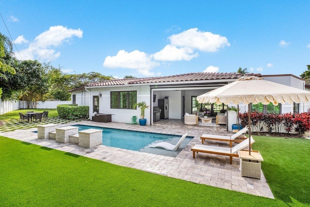 rear view of house featuring a patio, fence, a tiled roof, a lawn, and stucco siding