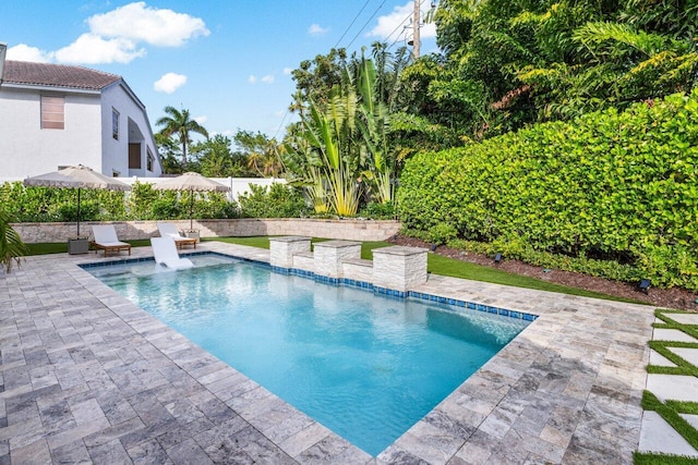 outdoor pool with a patio area and fence