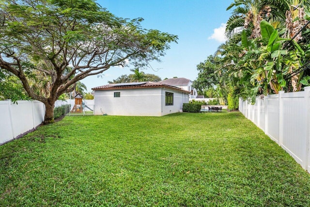 view of yard with a fenced backyard and a gate