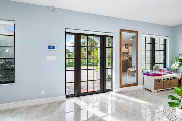 doorway with marble finish floor, french doors, and baseboards