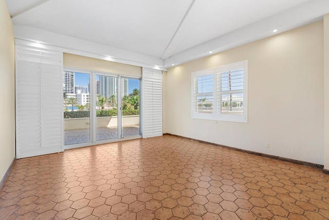 spare room featuring plenty of natural light, baseboards, vaulted ceiling, and recessed lighting