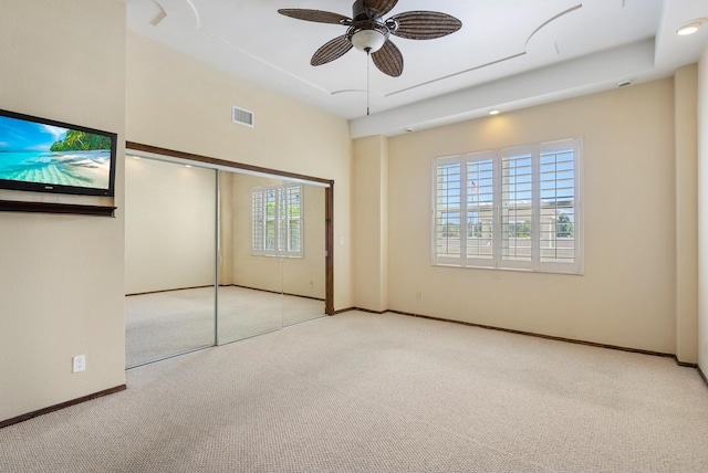 unfurnished bedroom featuring carpet floors, multiple windows, visible vents, and baseboards