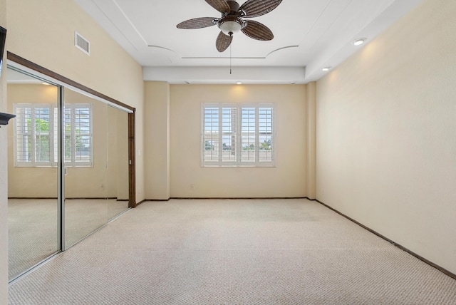 spare room featuring attic access, light colored carpet, visible vents, and baseboards