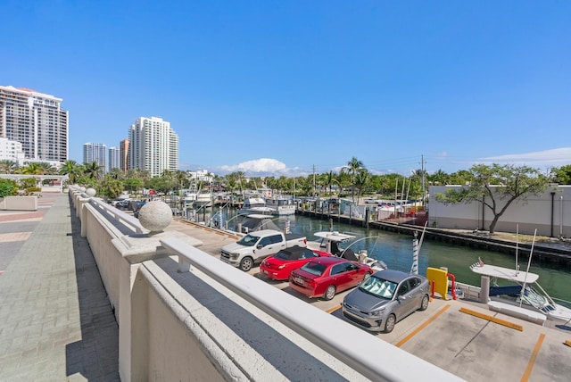 balcony featuring a view of city, a water view, and a boat dock