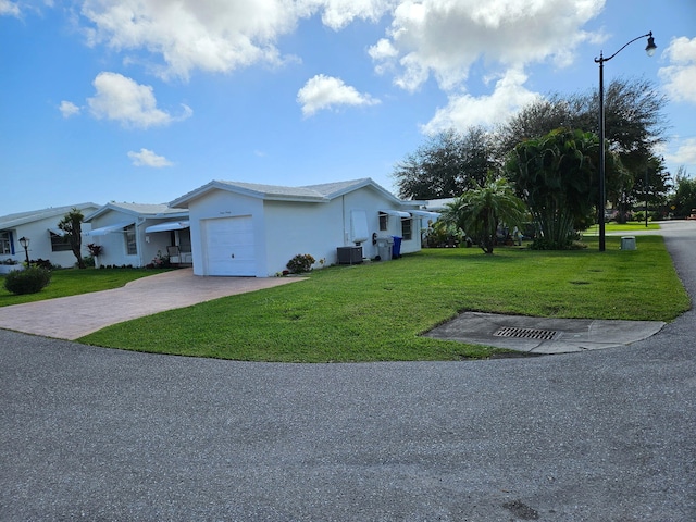 view of property exterior featuring central AC, a garage, and a lawn