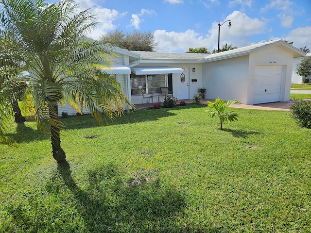 view of front of home with an attached garage, a front lawn, and stucco siding