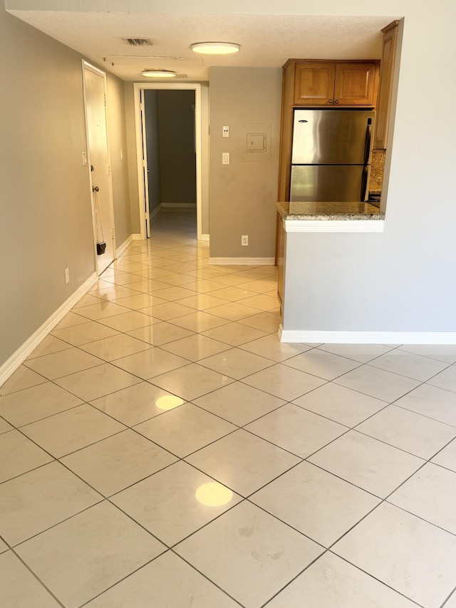 spare room with visible vents, baseboards, and light tile patterned flooring