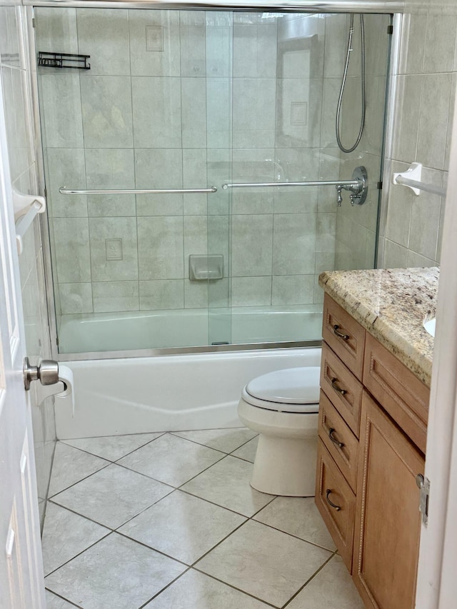 bathroom featuring vanity, tile patterned floors, toilet, and shower / bath combination with glass door