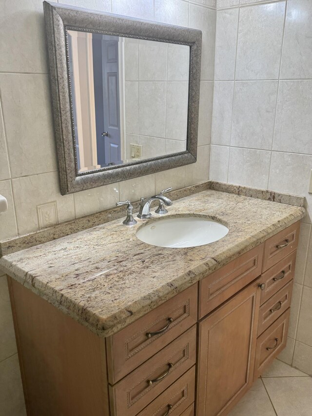 bathroom featuring vanity, tile patterned flooring, and tile walls
