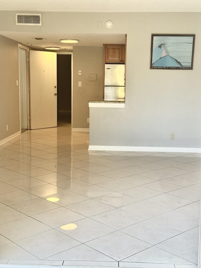spare room with visible vents, baseboards, and light tile patterned floors