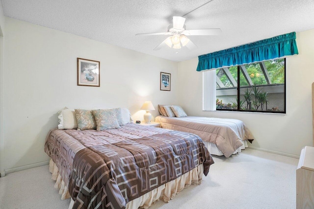 bedroom featuring ceiling fan, light carpet, and a textured ceiling