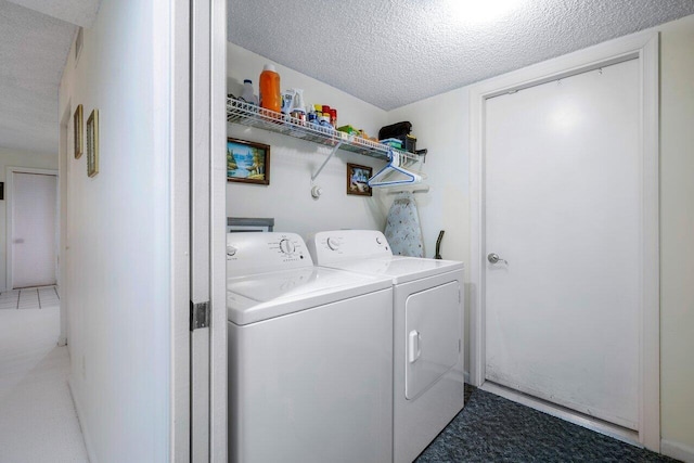 laundry area featuring washing machine and dryer and a textured ceiling