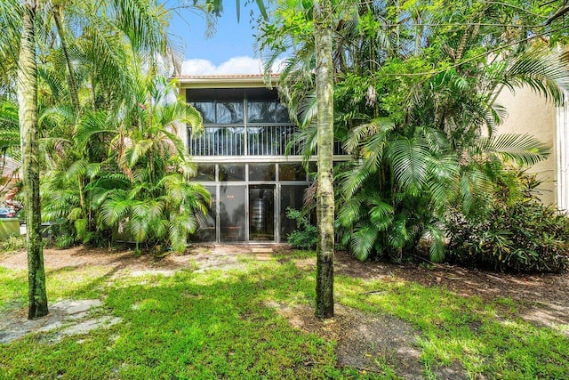 rear view of property featuring a sunroom