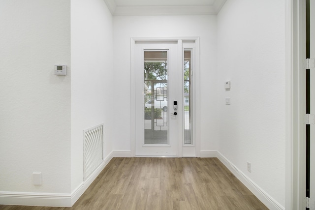 entryway featuring ornamental molding and light hardwood / wood-style floors