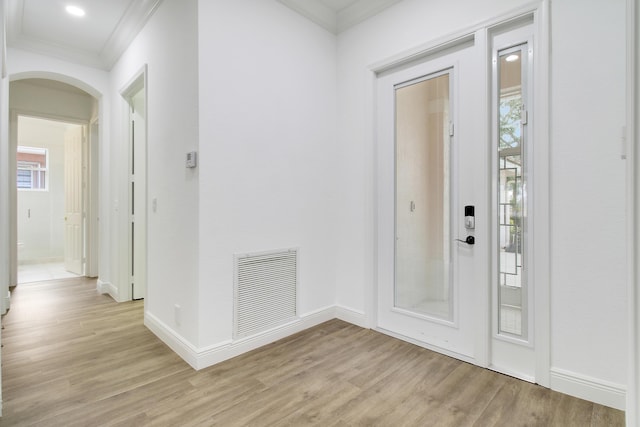 foyer featuring crown molding and light wood-type flooring