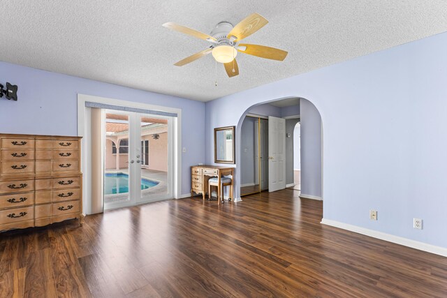 unfurnished room with ceiling fan, dark wood-type flooring, french doors, and a textured ceiling