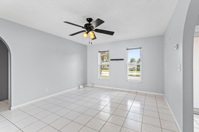 dining space featuring a textured ceiling, ceiling fan, and light tile patterned floors