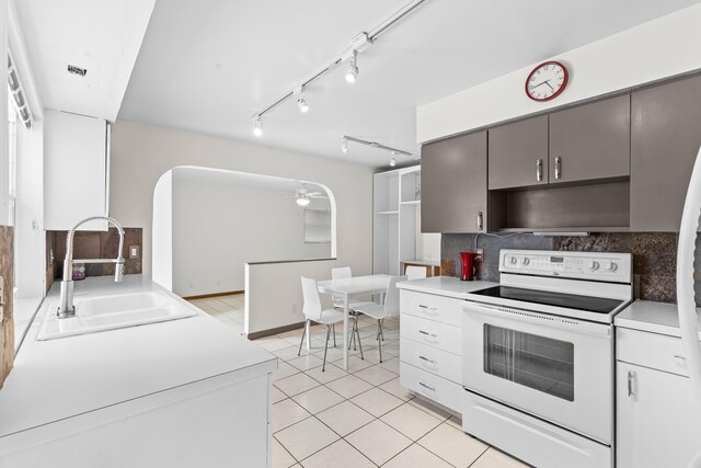 kitchen with white cabinetry, sink, backsplash, white appliances, and light tile patterned floors