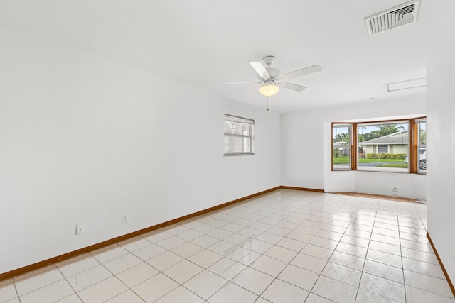 tiled empty room featuring a wealth of natural light and ceiling fan