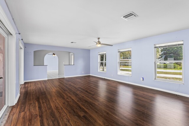 empty room with ceiling fan, dark wood-type flooring, and a textured ceiling