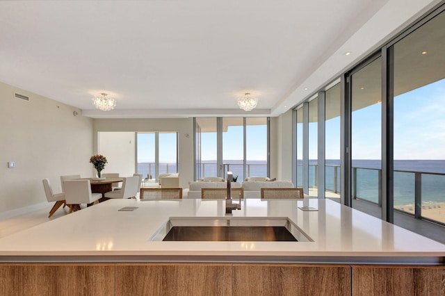 kitchen with sink, a center island with sink, and a water view