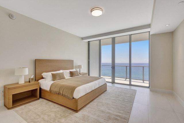 bedroom featuring floor to ceiling windows, a water view, light tile patterned flooring, and access to exterior