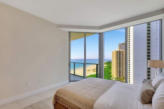 bedroom with a water view, access to exterior, and light tile patterned flooring