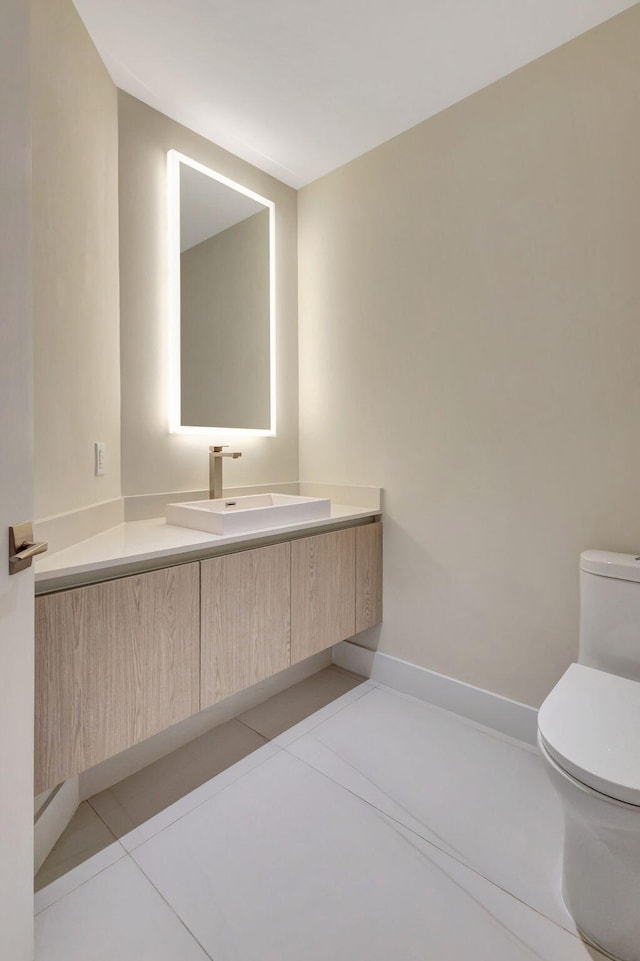 bathroom featuring vanity, tile patterned floors, and toilet