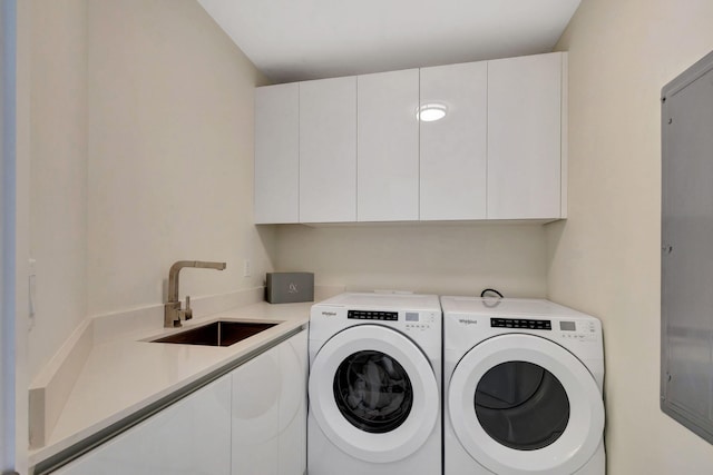 laundry area featuring sink, washer and clothes dryer, and cabinets