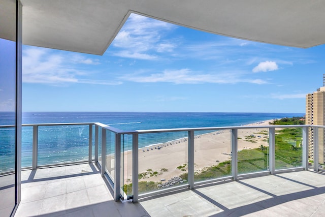 balcony featuring a water view and a beach view